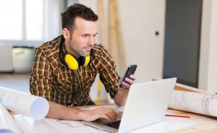 remodeling contractor texting at jobsite.