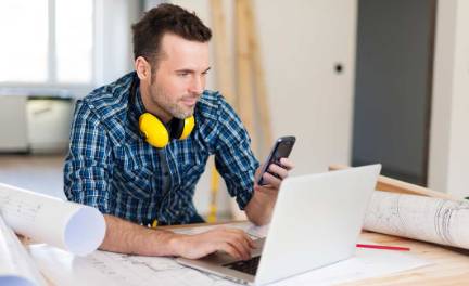 home service contractor texting at jobsite.